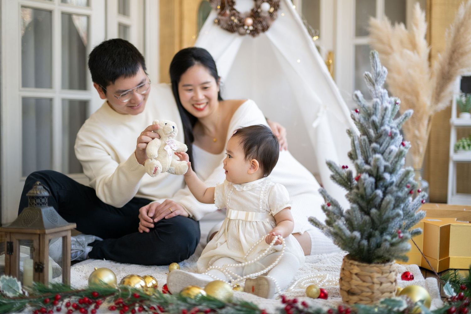 A family enjoys holiday moments together in a cozy living room decorated with a Christmas tree.