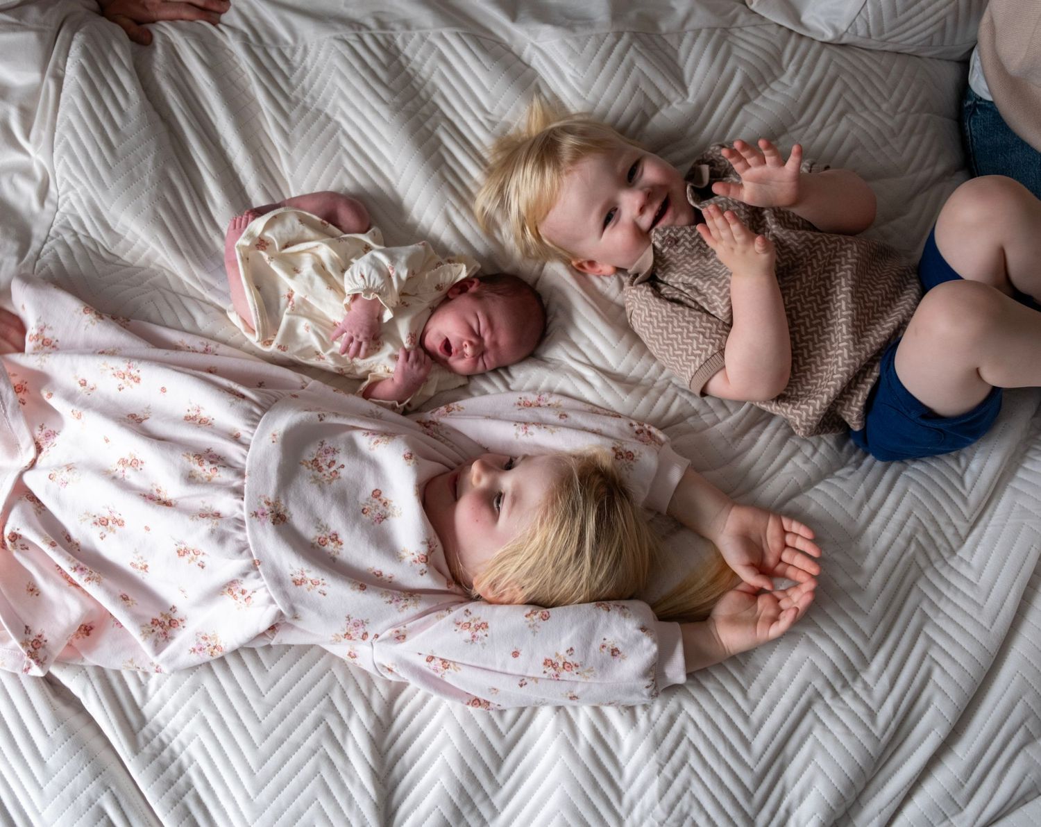 A sequence of six photos showing a baby lying on a textured white blanket in different sleeping positions.