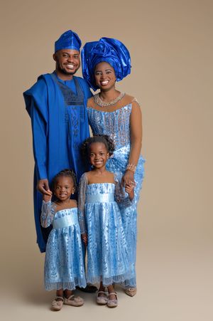 African family of four wearing matching royal blue traditional attire, posing together for a formal portrait photo.