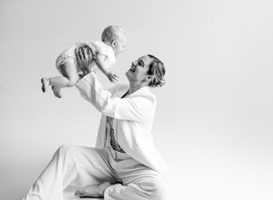 A sequence of black and white photos showing two dancers performing contemporary dance moves in white clothing.