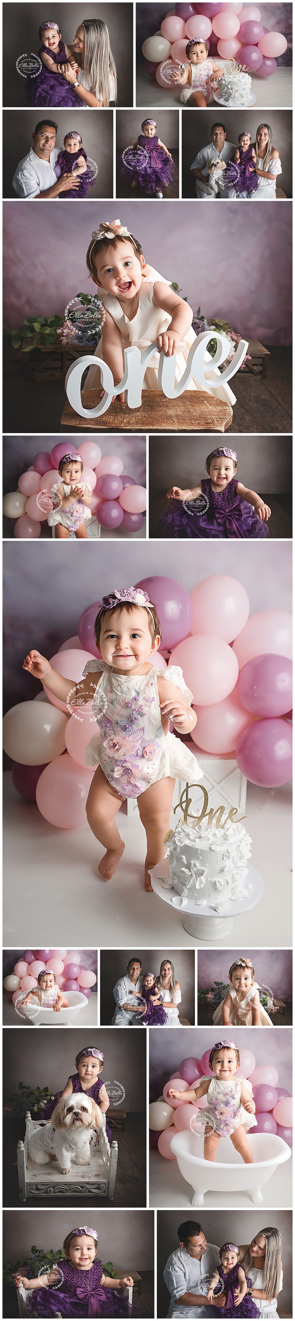 First birthday photo session with pink and white balloons, purple tulle, and a decorative 'one' sign in rustic setting.