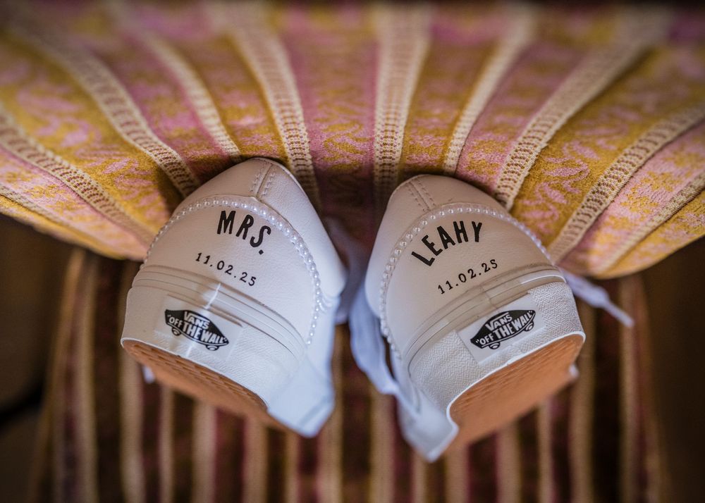 Row of personalized cowboy boots lined up against a rustic wooden background.