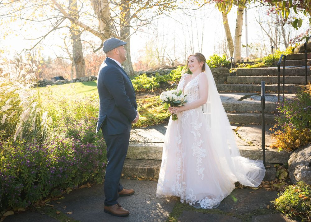 Wedding couple poses in a series of candid moments against a stone wall and autumn foliage backdrop.
