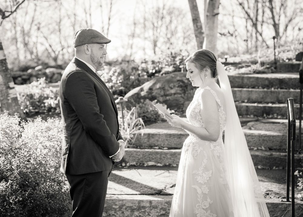 Wedding couple standing together outdoors in a black and white photograph.