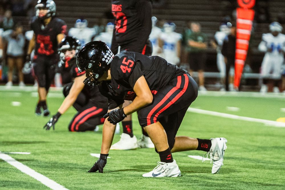 Football player on the line, ready to run