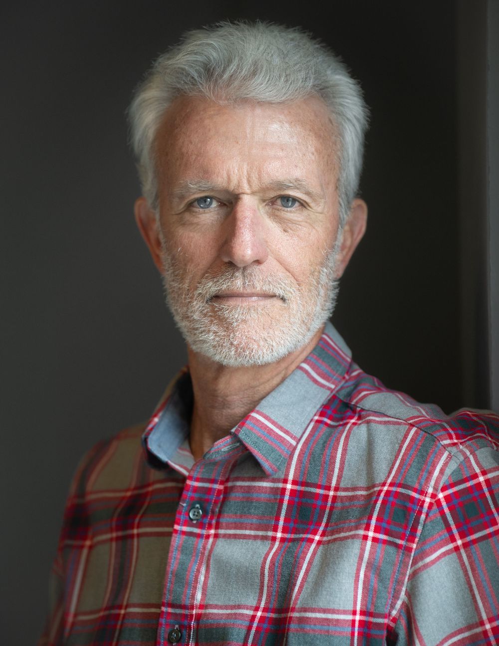 Older man with gray hair and beard wearing a plaid shirt, portrait photo. Best photographer Williamsburg VA
