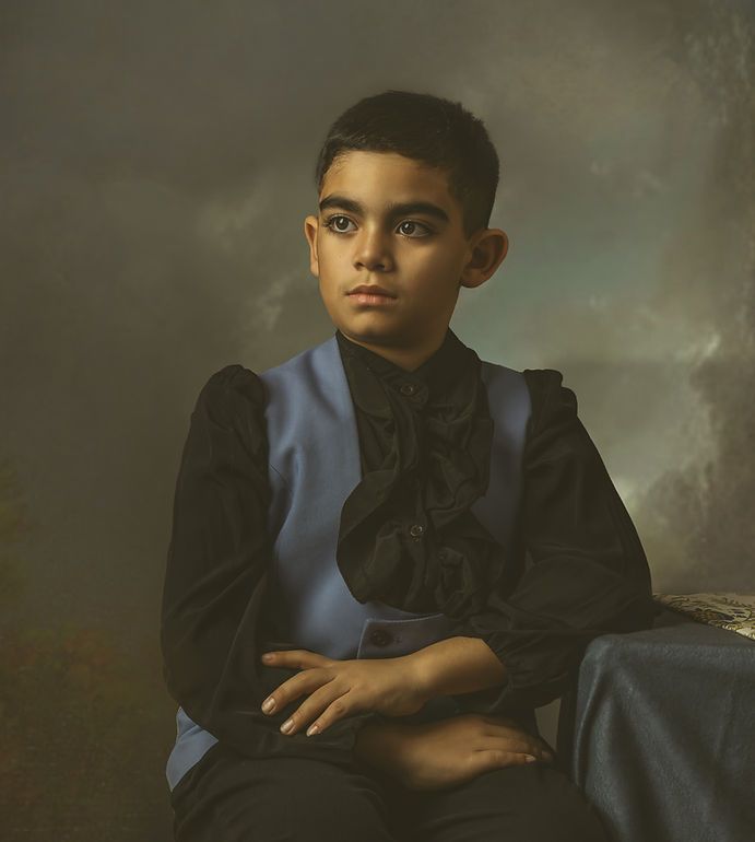 Formal portrait of a young boy in a blue vest and black shirt with a painterly background.