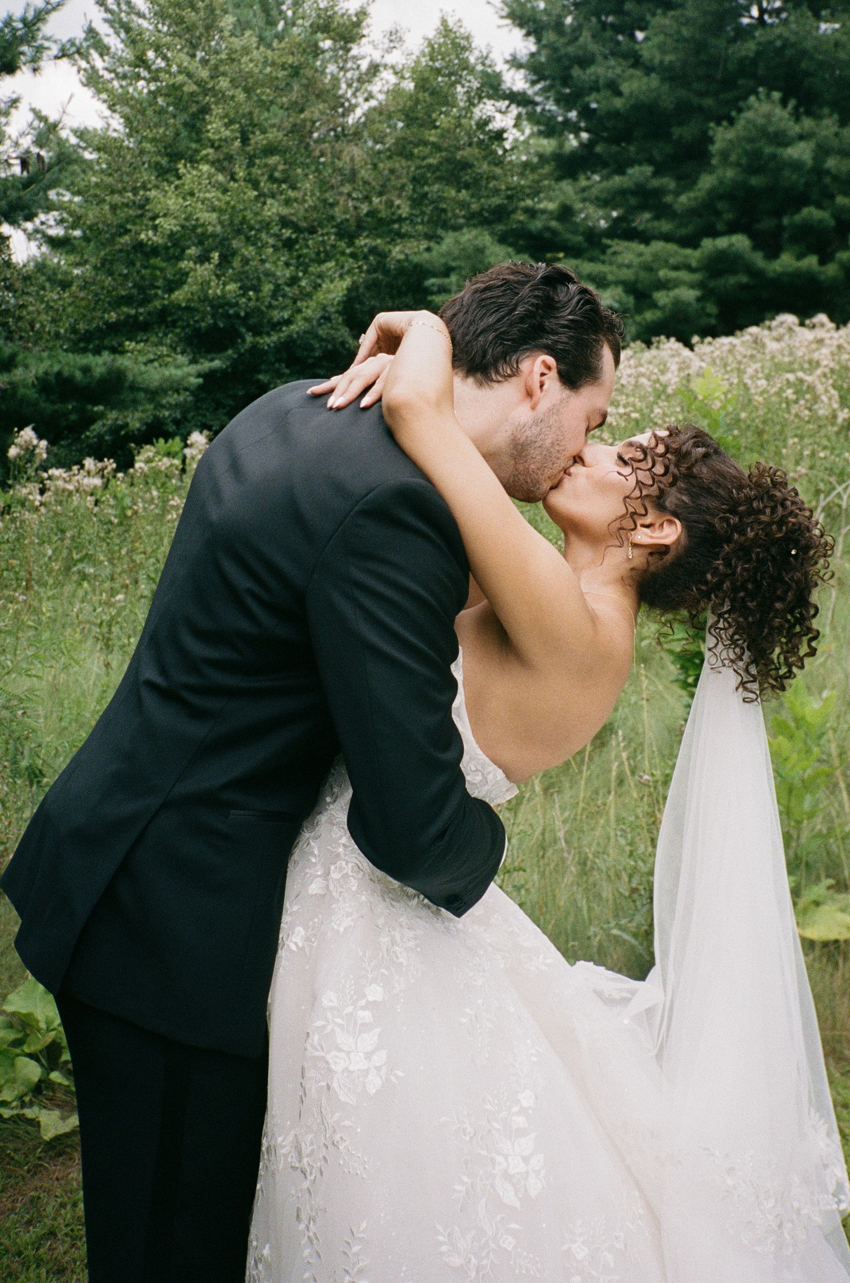 Romantic wedding couple sharing passionate kisses in a series of photos set against a lush green outdoor backdrop.