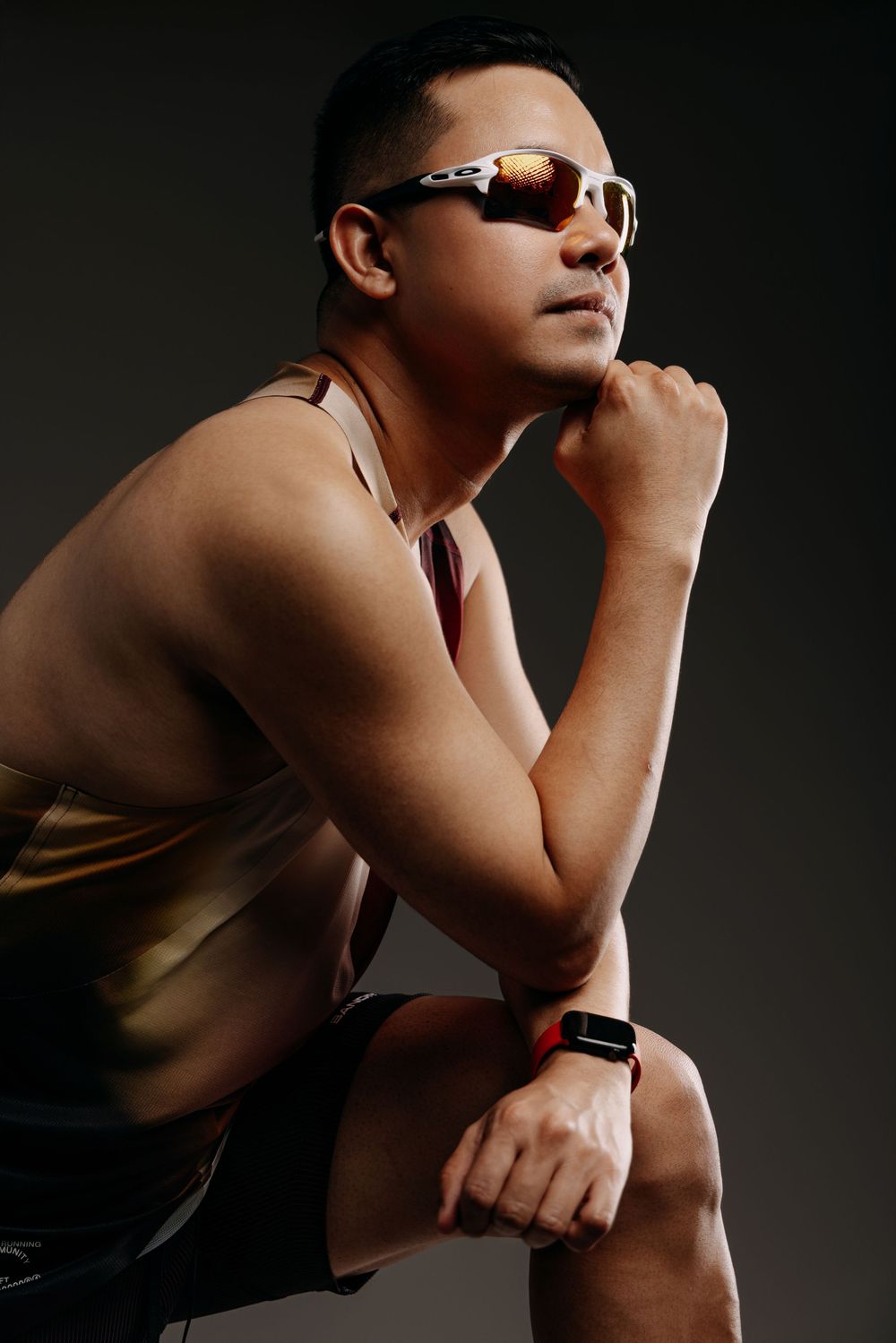 Artistic portrait showing a shirtless figure in dramatic lighting wearing sunglasses and a watch.