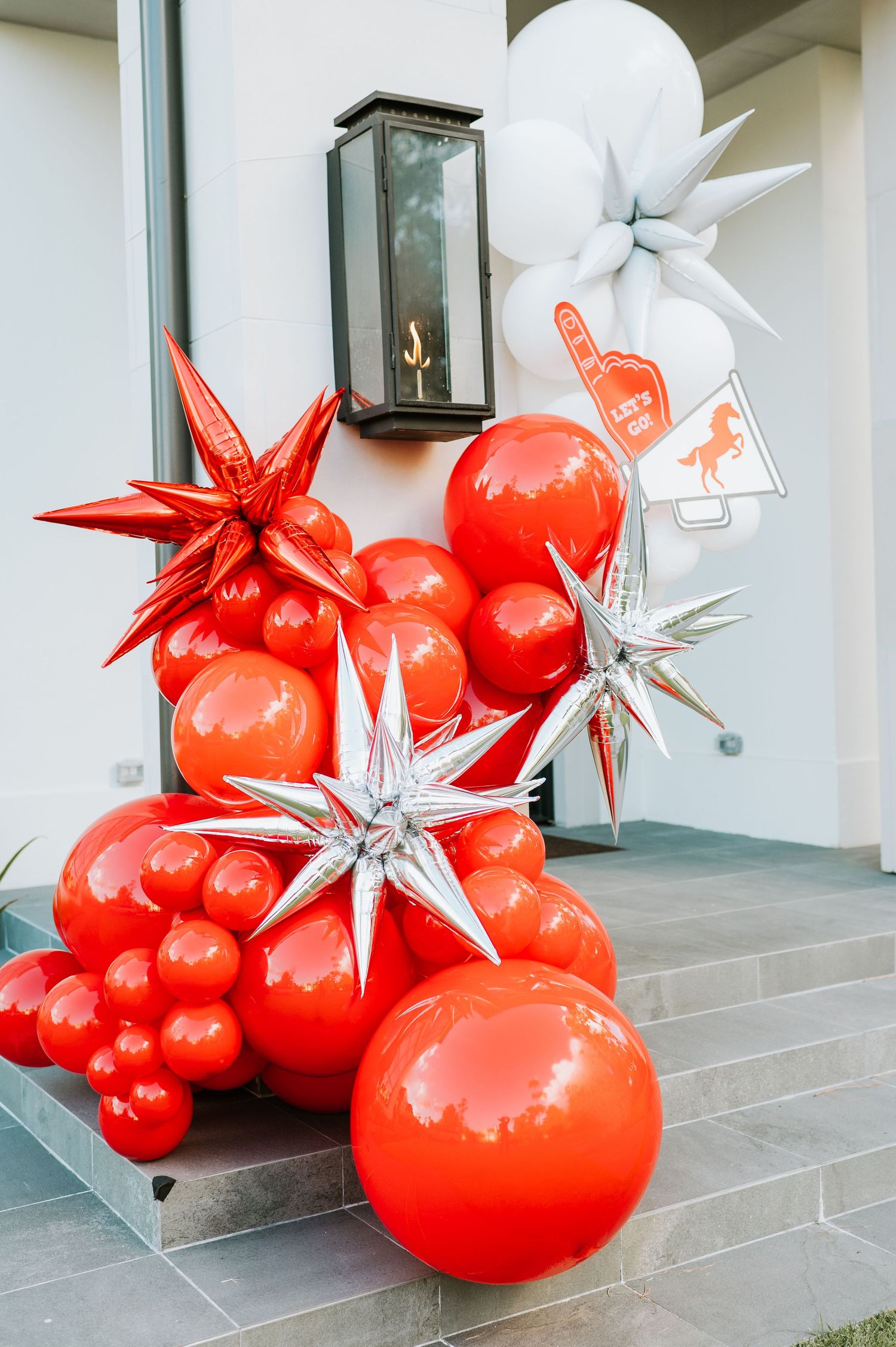 Red and white star-shaped holiday decorations displayed on outdoor steps create a festive entrance arrangement.