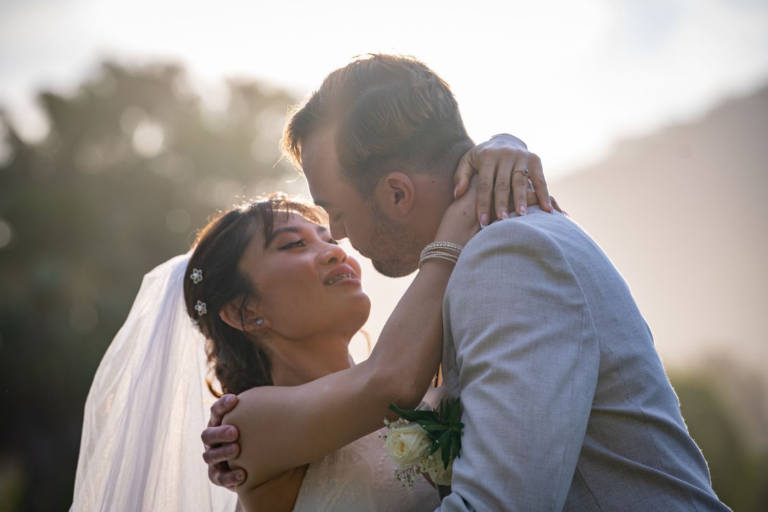 Romantic wedding couple shares intimate moments during golden hour photography session in an outdoor setting.