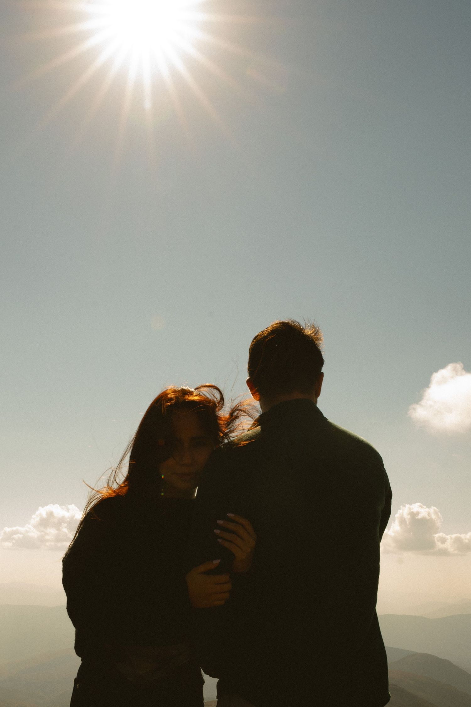 Memory Lane Studios couple silhouette embracing under bright sunlight on Mt Washington mountain peak engagement photography