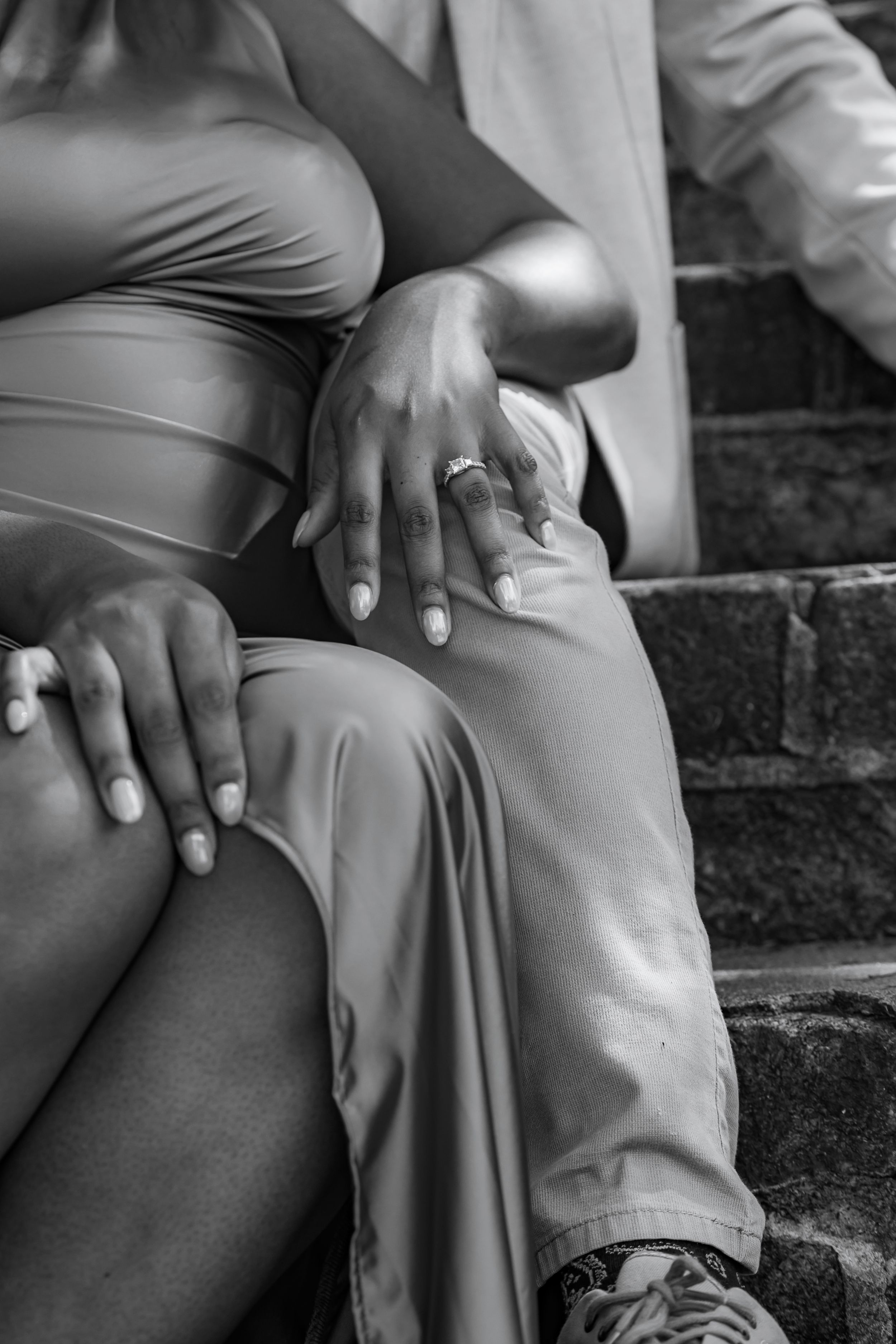 Black and white artistic photograph series showing close-up details of hands resting on fabric in various poses.