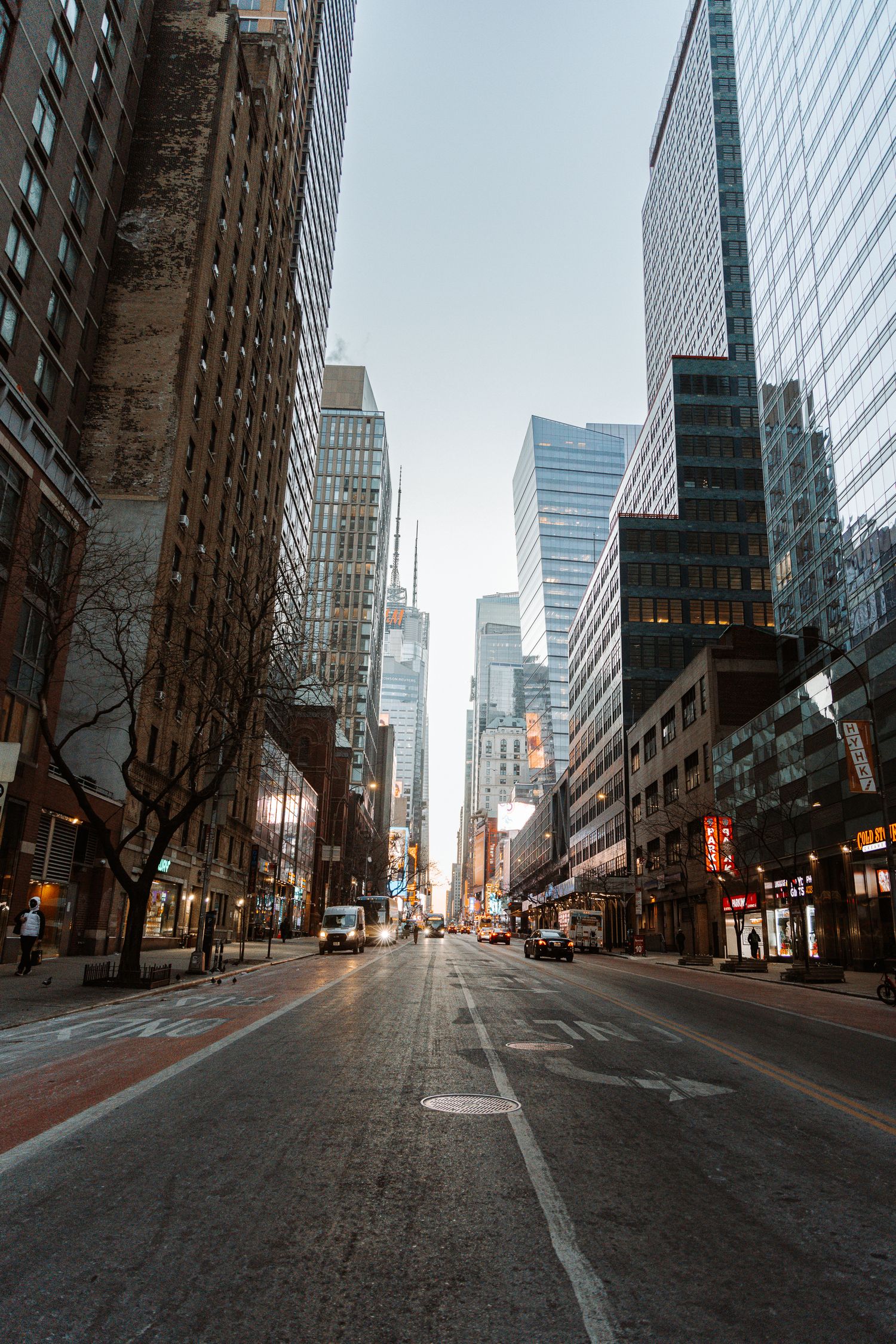 Urban street view of tall buildings and skyscrapers at dusk in a downtown city setting.