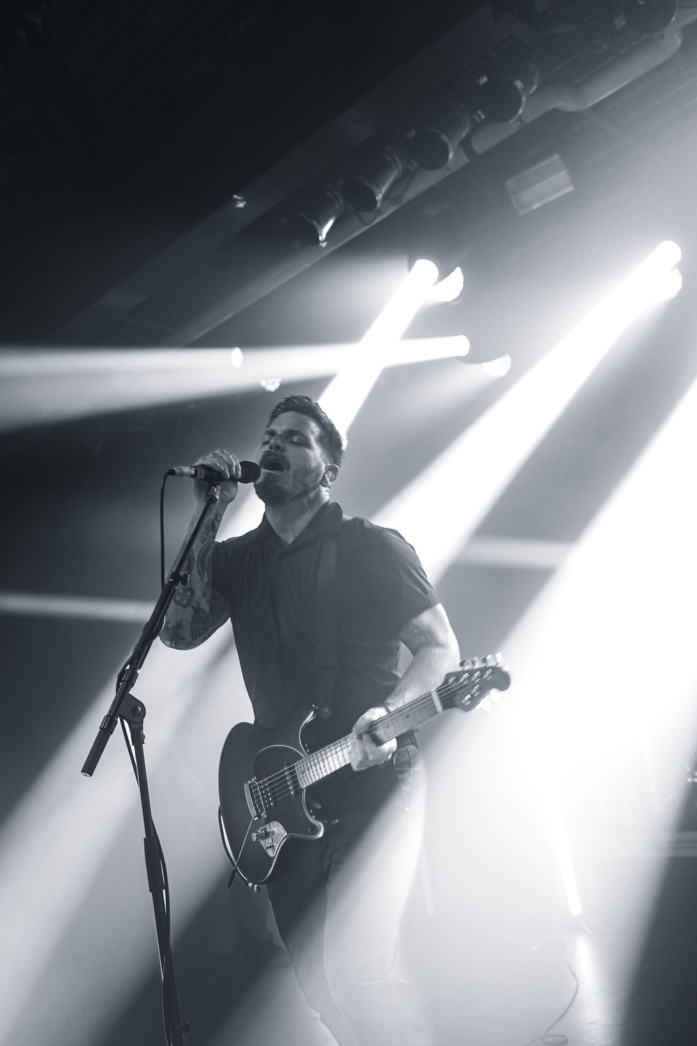 Moody concert photography sequence showing silhouetted performer with guitar against bright stage lights.