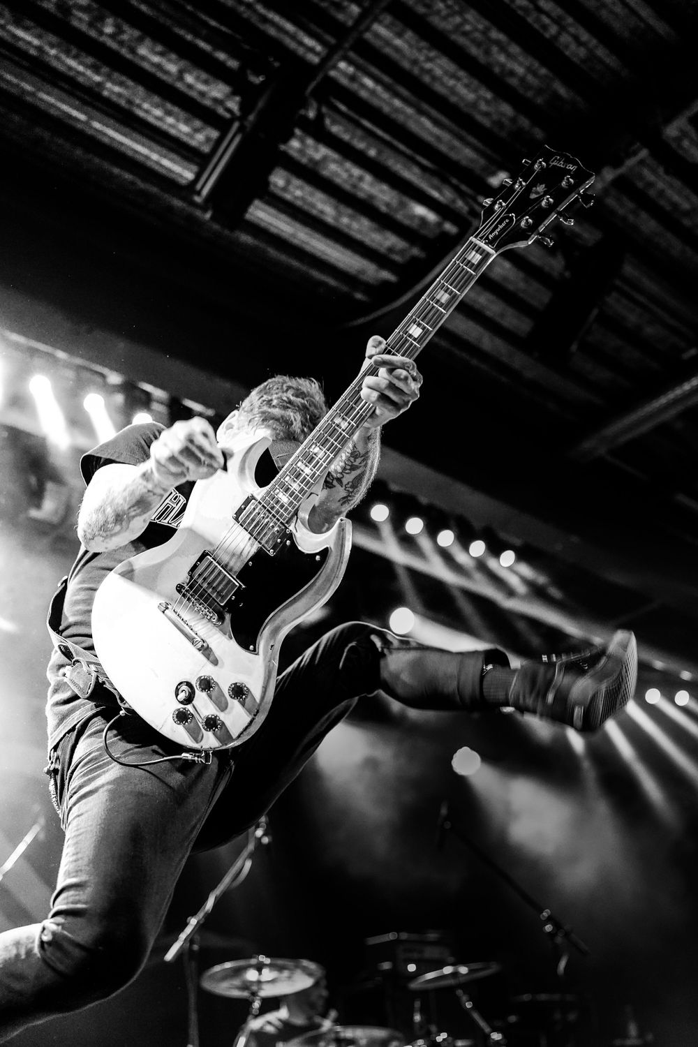Dynamic black and white sequence of a guitarist performing on stage with dramatic lighting and energetic movements.