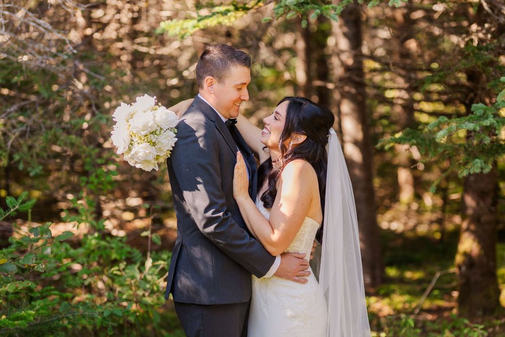 Romantic wedding couple shares intimate moments in a lush forest setting during their outdoor photo session.