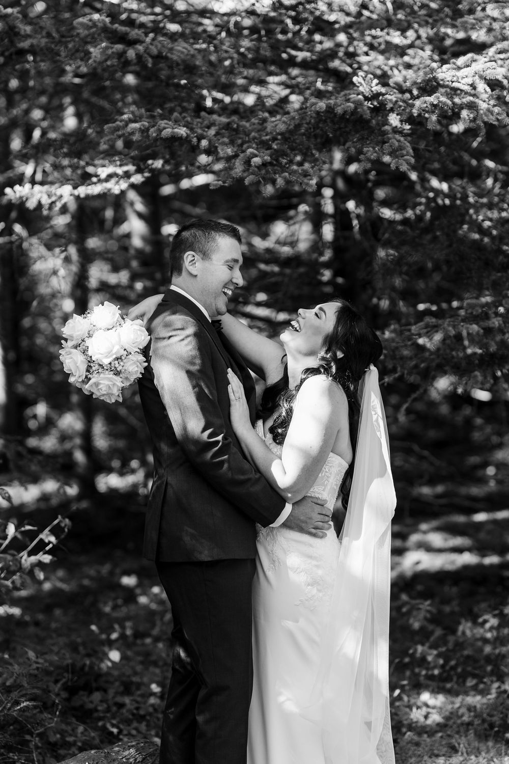 A romantic black and white photo sequence of a couple dancing together under flowering trees in a garden setting.