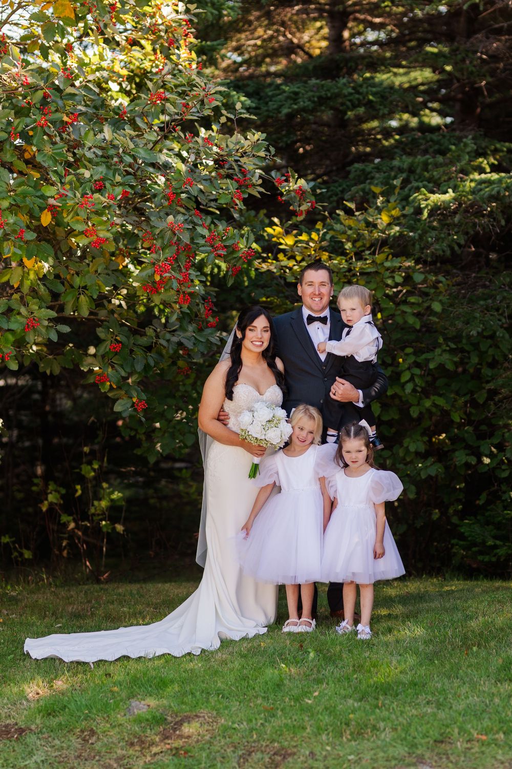 Wedding party photos featuring the bride and young flower girls in white dresses against a lush garden backdrop.