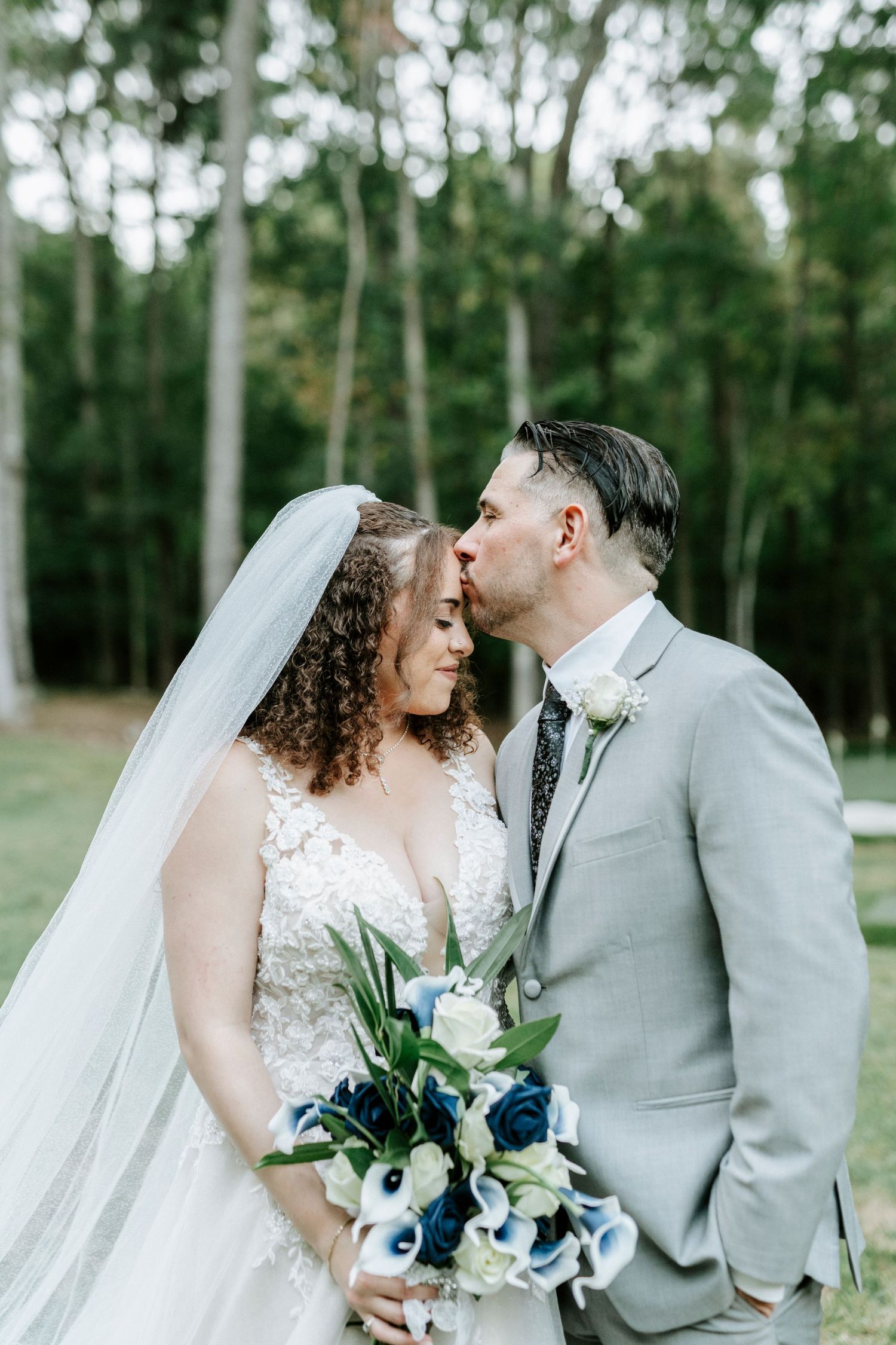 Romantic outdoor wedding portraits with a couple in grey and white attire among birch trees.