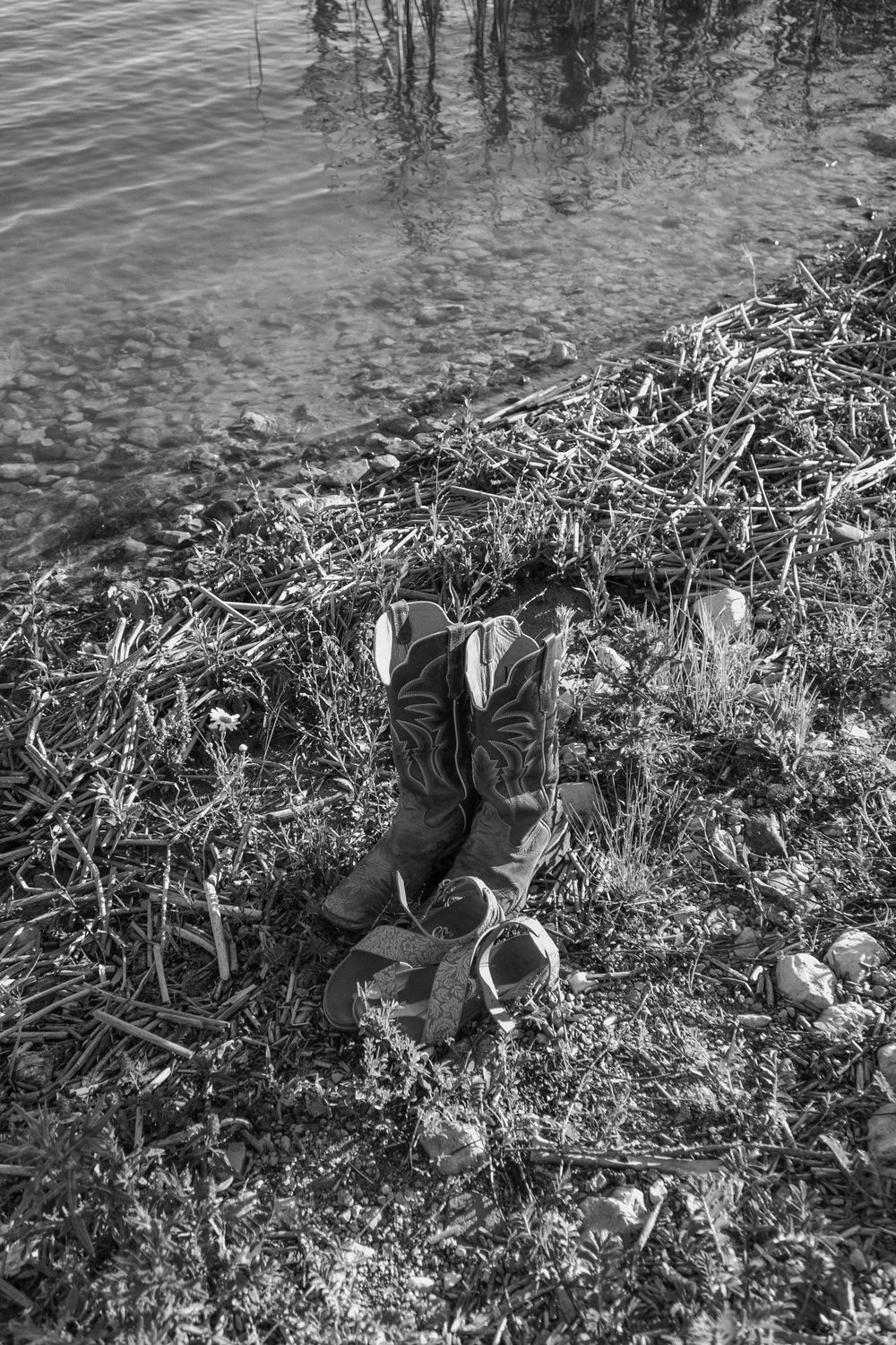 A series of vintage black and white photographs showing someone sitting on a grassy riverbank.