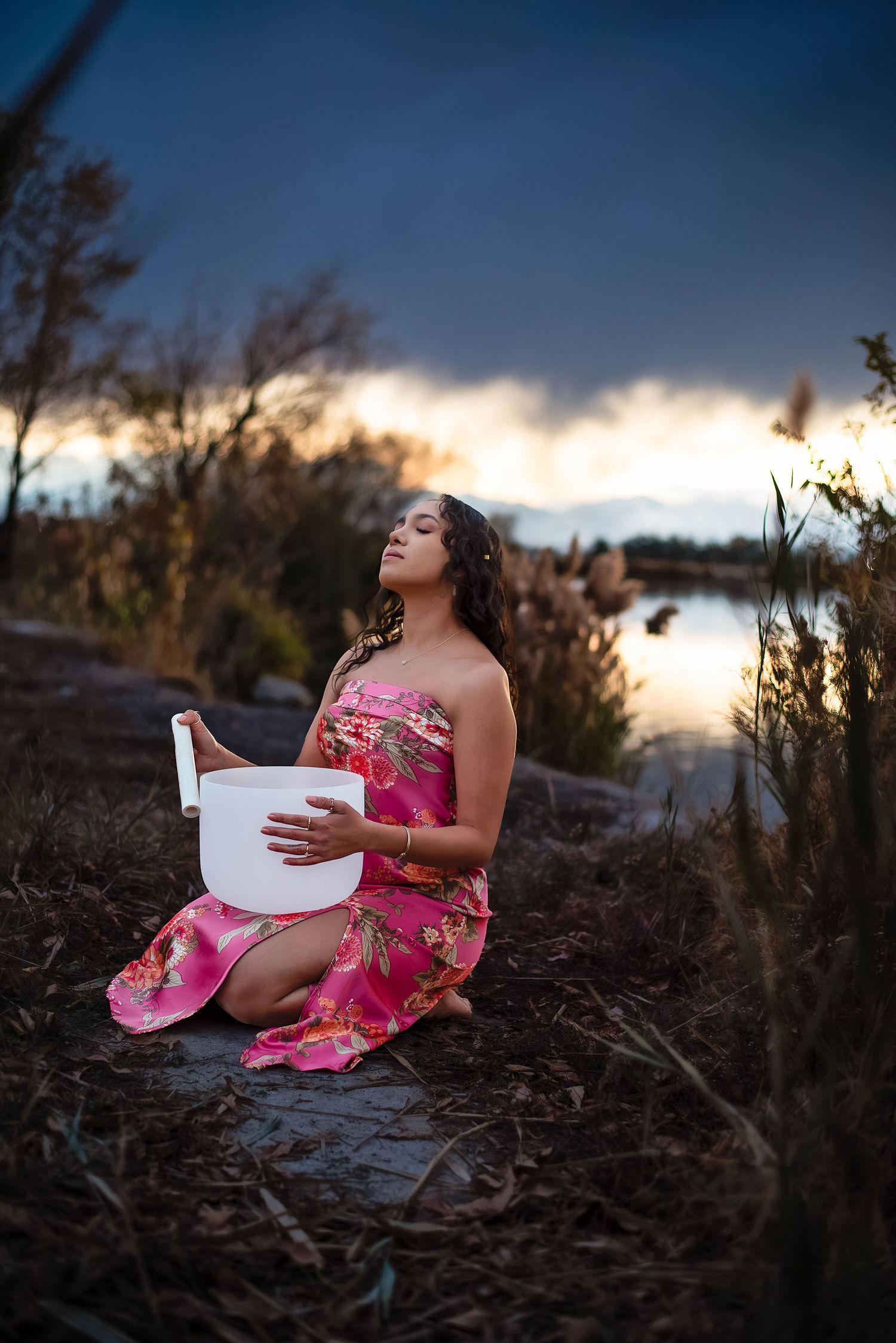Sunset is setting at the pond with a woman meditating