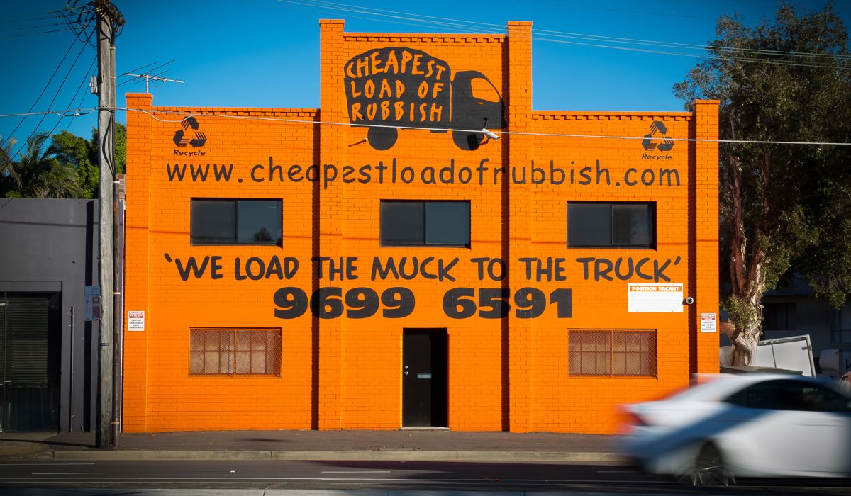 Bright orange commercial building with 'We Load The Mock To The Truck' sign in Los Angeles.