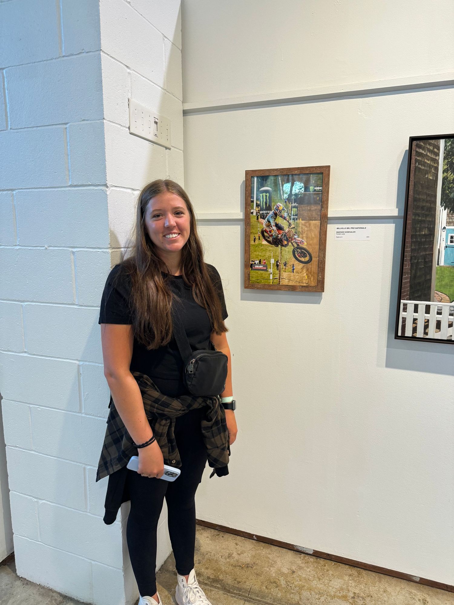 Interior hallway with white walls and black framed artwork displayed.