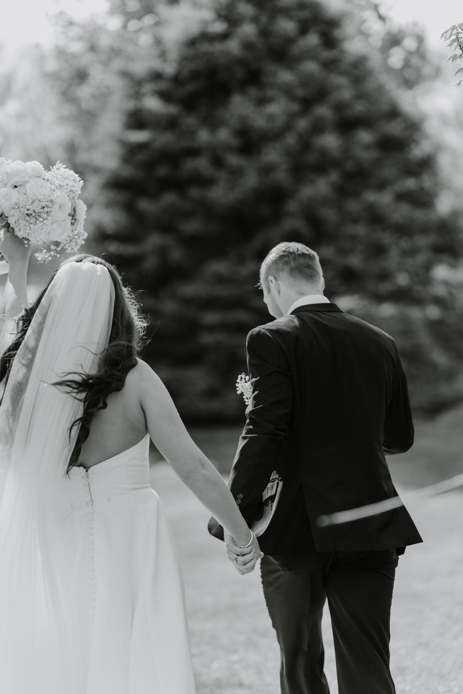 A black and white sequence shows a wedding couple walking together in an outdoor setting.
