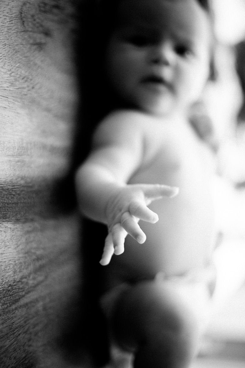 A series of moody black and white images show a hand reaching out through blurred shadows and light.