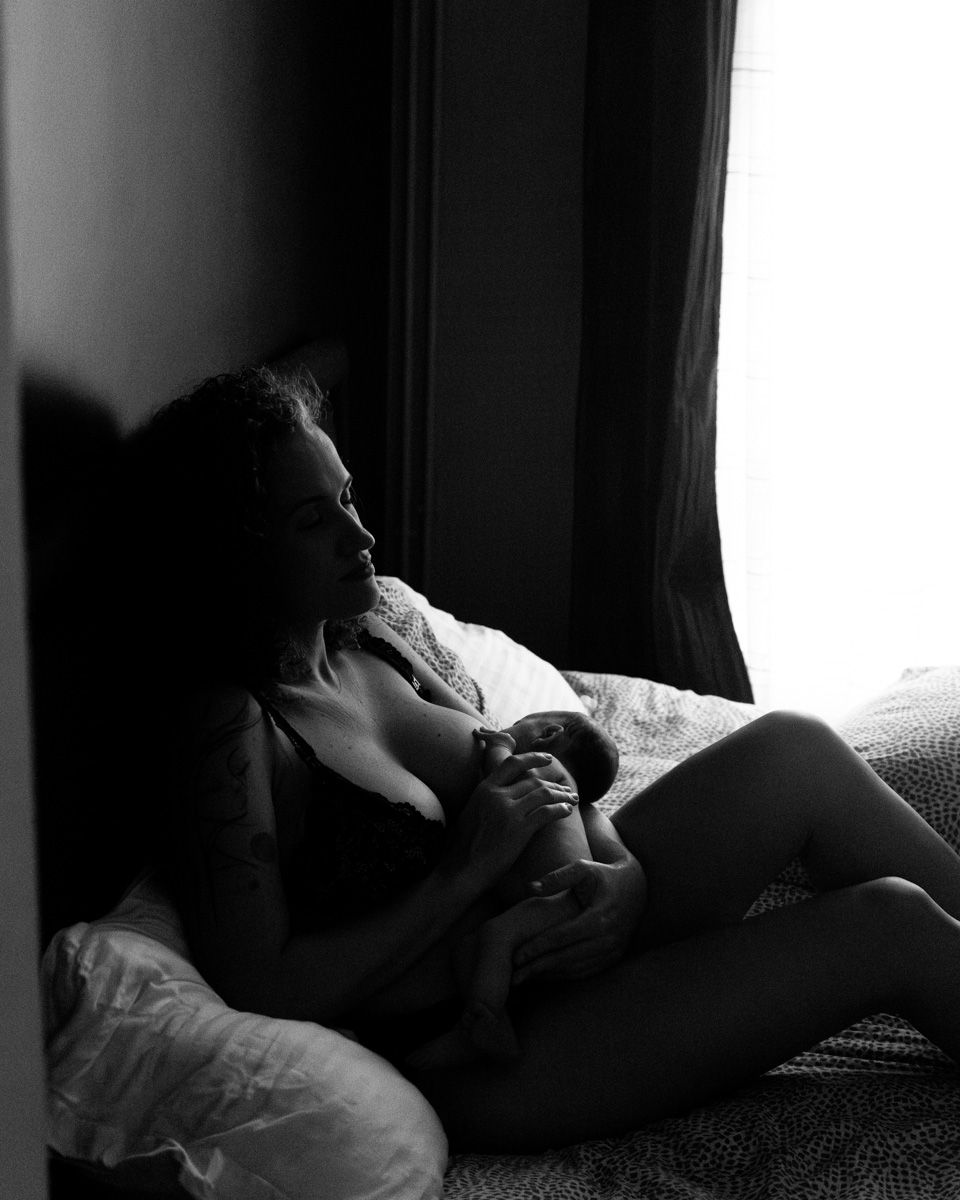 Silhouetted figure sitting by window in contemplative pose.