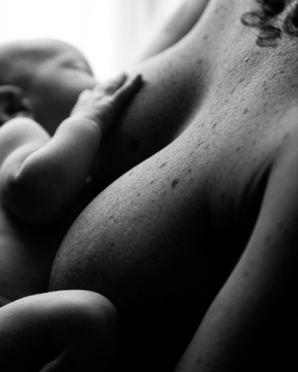 Black and white artistic photo of nursing infant.