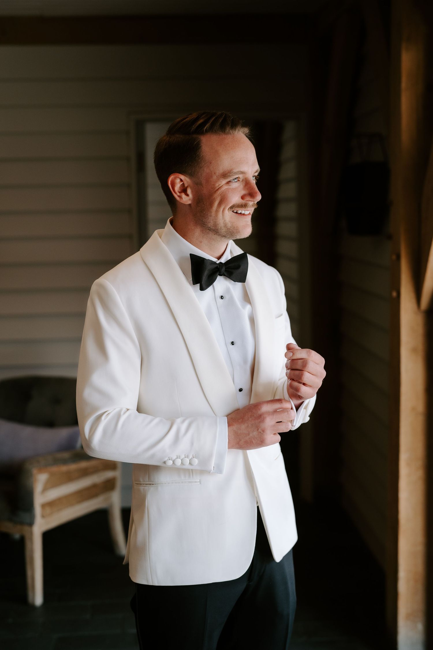 Tunnels Beach Wedding Venue in North Devon, Groom smiling out of window