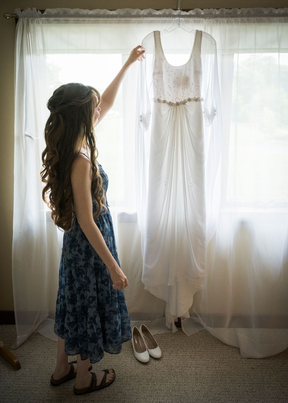 A series of shots showing a blue floral dress against white curtains in a room.