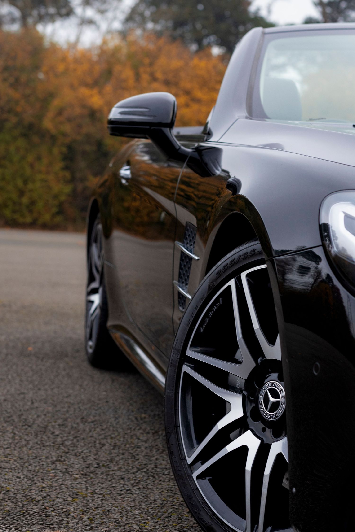 Close-up of sleek black luxury car with custom alloy wheel.