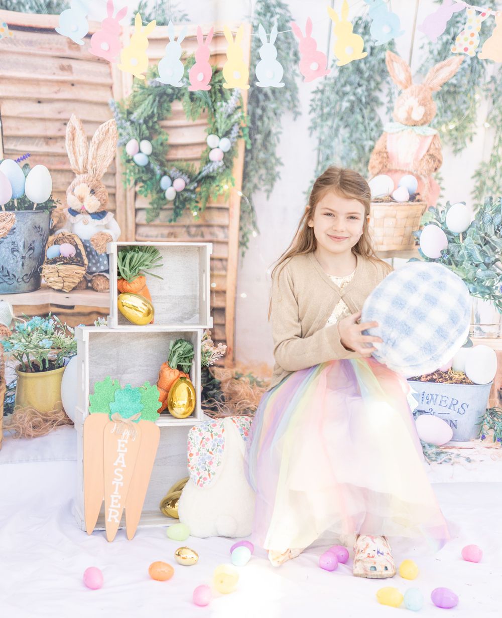 Easter spring photo setup with wooden crates, pastel decorations, colorful eggs and tulle skirt in soft dreamy lighting.