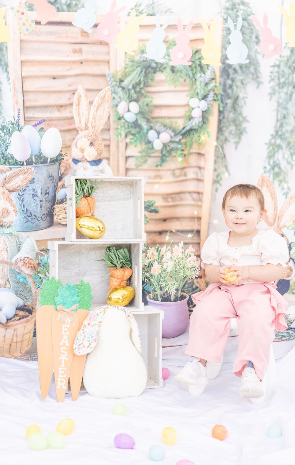 Soft pastel Easter scene with white shelves, decorative wreath, carrots, and spring decor in a dreamy light setting.