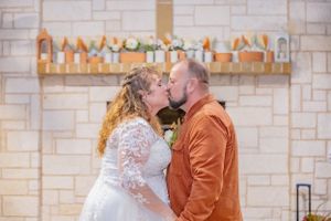 Couple sharing a romantic dance moment in a rustic stone-walled venue.