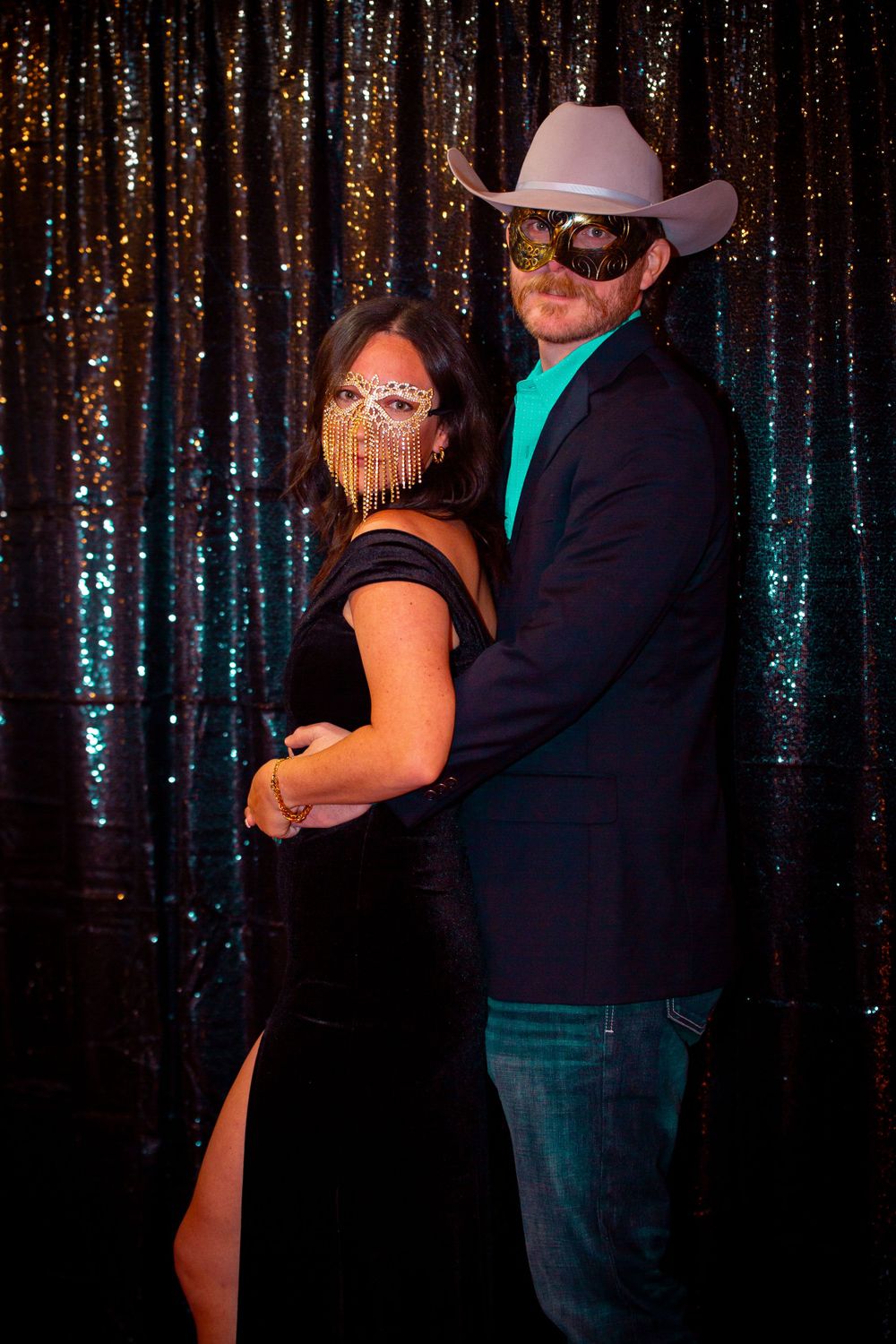 Couples dancing in front of a glittering backdrop at a formal event.