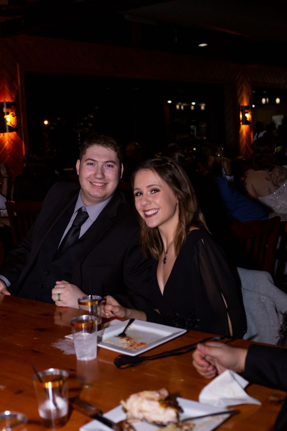 Friends gathered around a table at a dimly lit restaurant or venue.