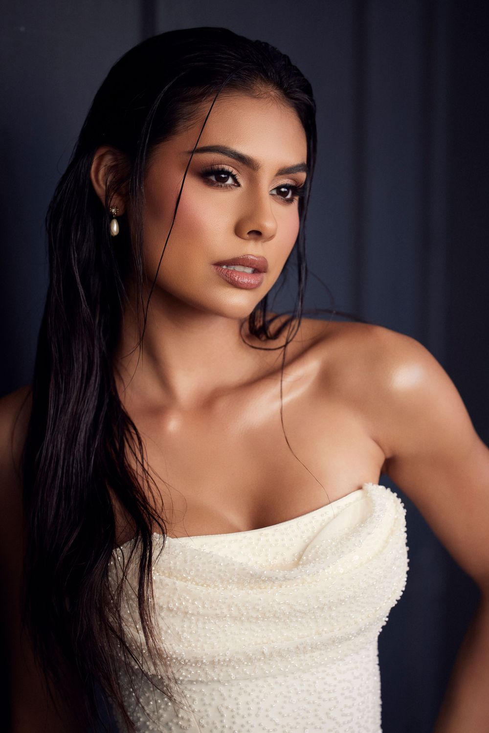 Dramatic portrait series featuring cream colored top against dark moody background.