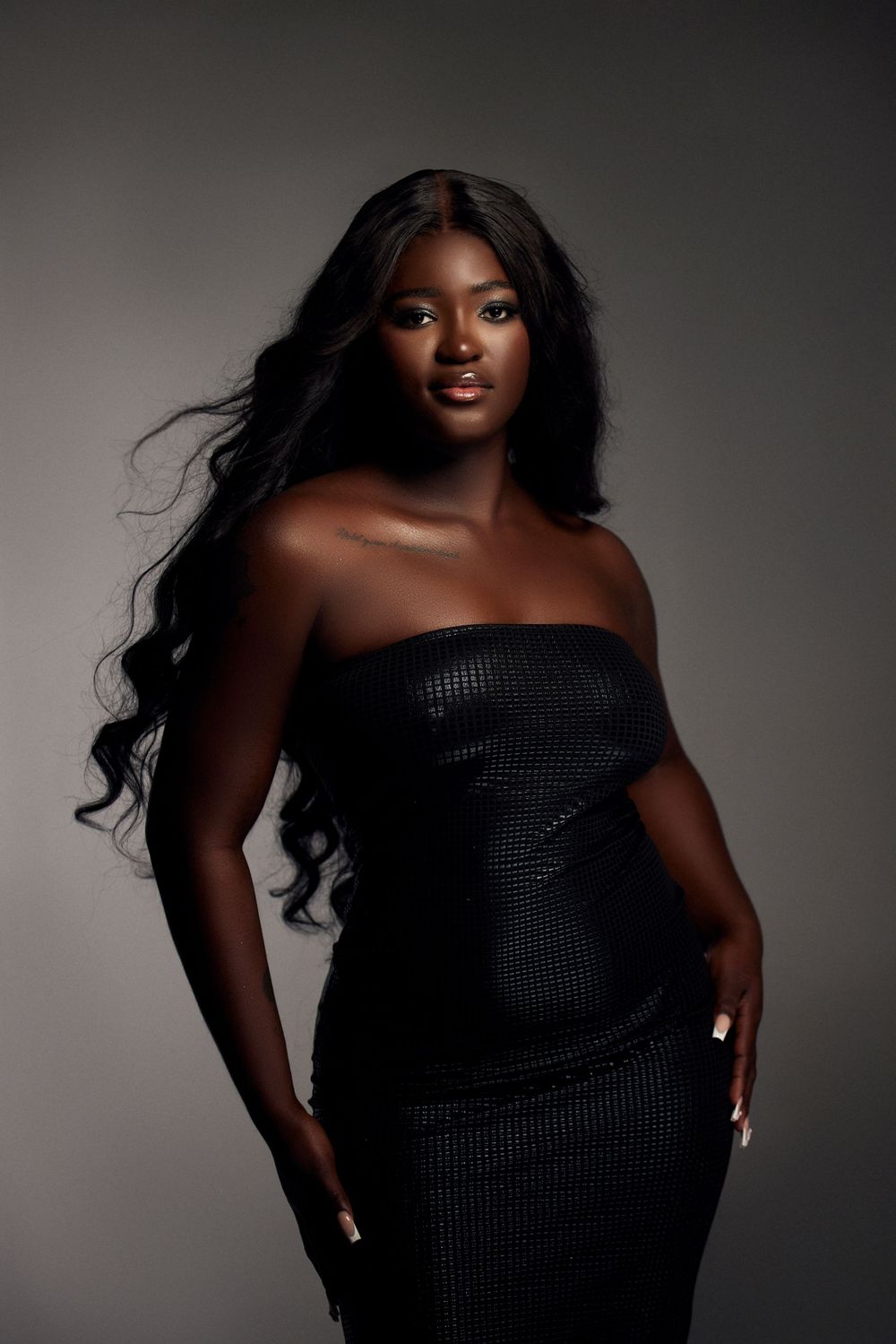 Fashion portrait series featuring textured black off-shoulder dress in moody lighting.