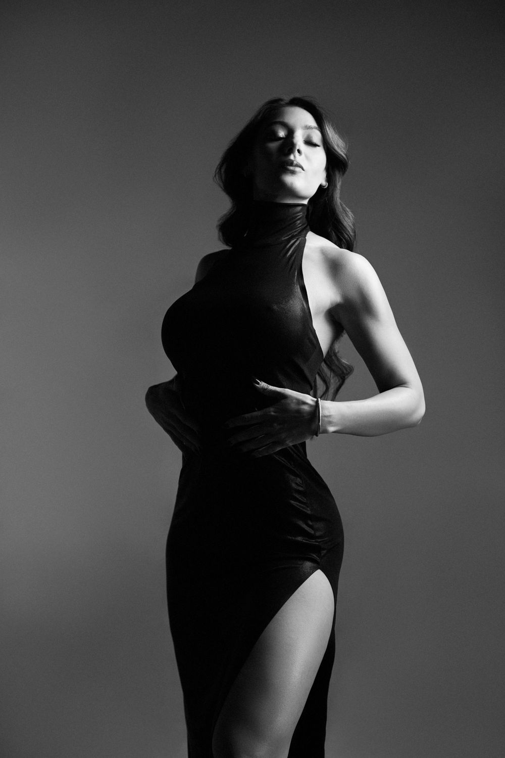 Artistic black and white silhouette of a figure in motion against dark background.