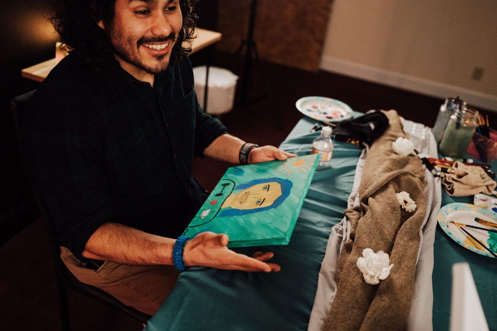 Fiancé is happy about portrait his fiancée did of him at Sip & paint date night at Nicolle Aponte Photography studio in Middletown, PA