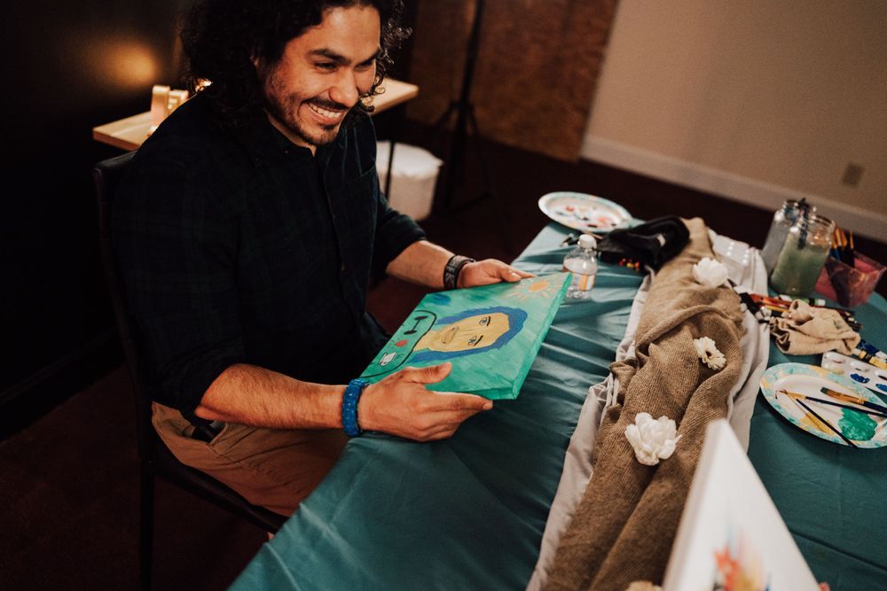 Fiancé is happy about portrait his fiancée did of him at Sip & paint date night at Nicolle Aponte Photography studio in Middletown, PA