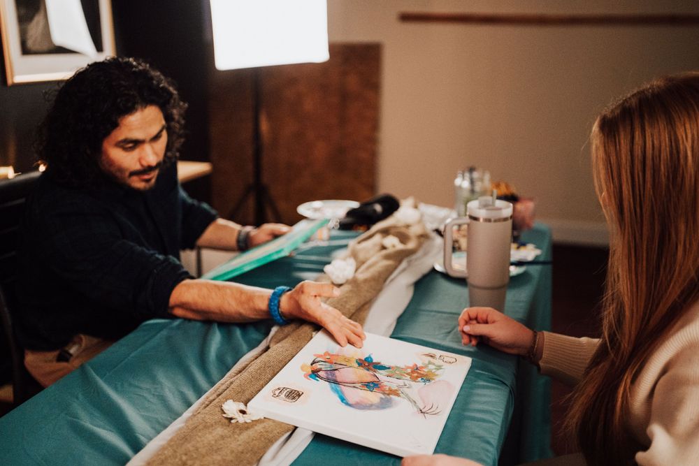 Fiancé is explaining portrait he painted at Sip & paint date night at Nicolle Aponte Photography studio in Middletown, PA