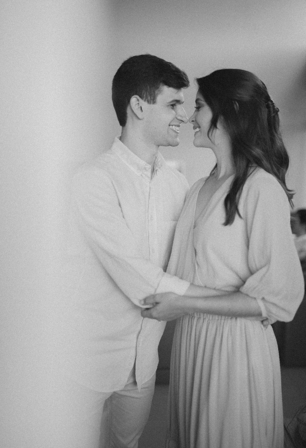 An intimate black and white portrait capturing a tender moment between a couple.