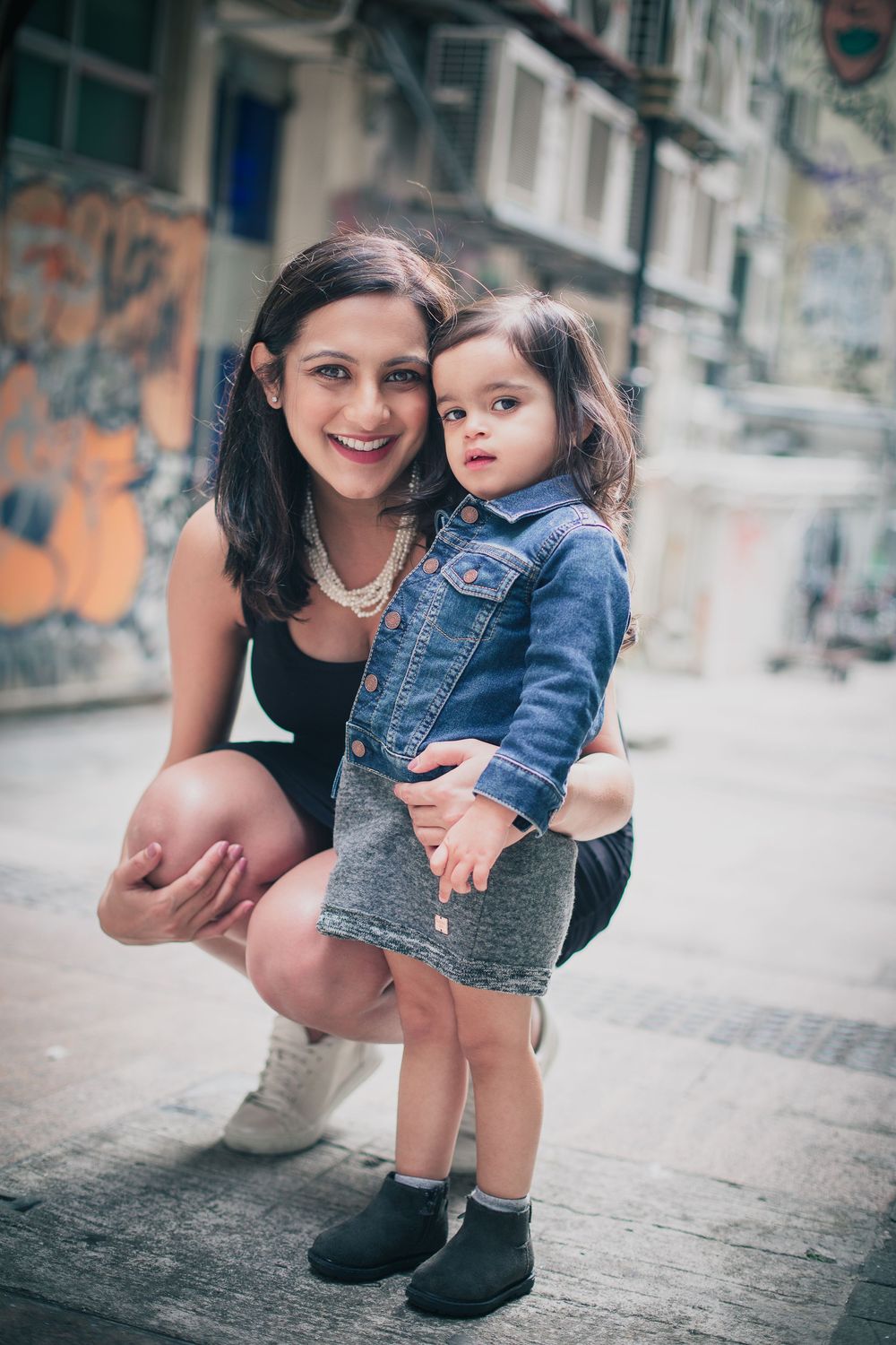 A sweet family moment captured on a city street with matching denim outfits.