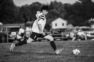 Close-up shots of soccer players kicking a ball on a grassy field during a match.