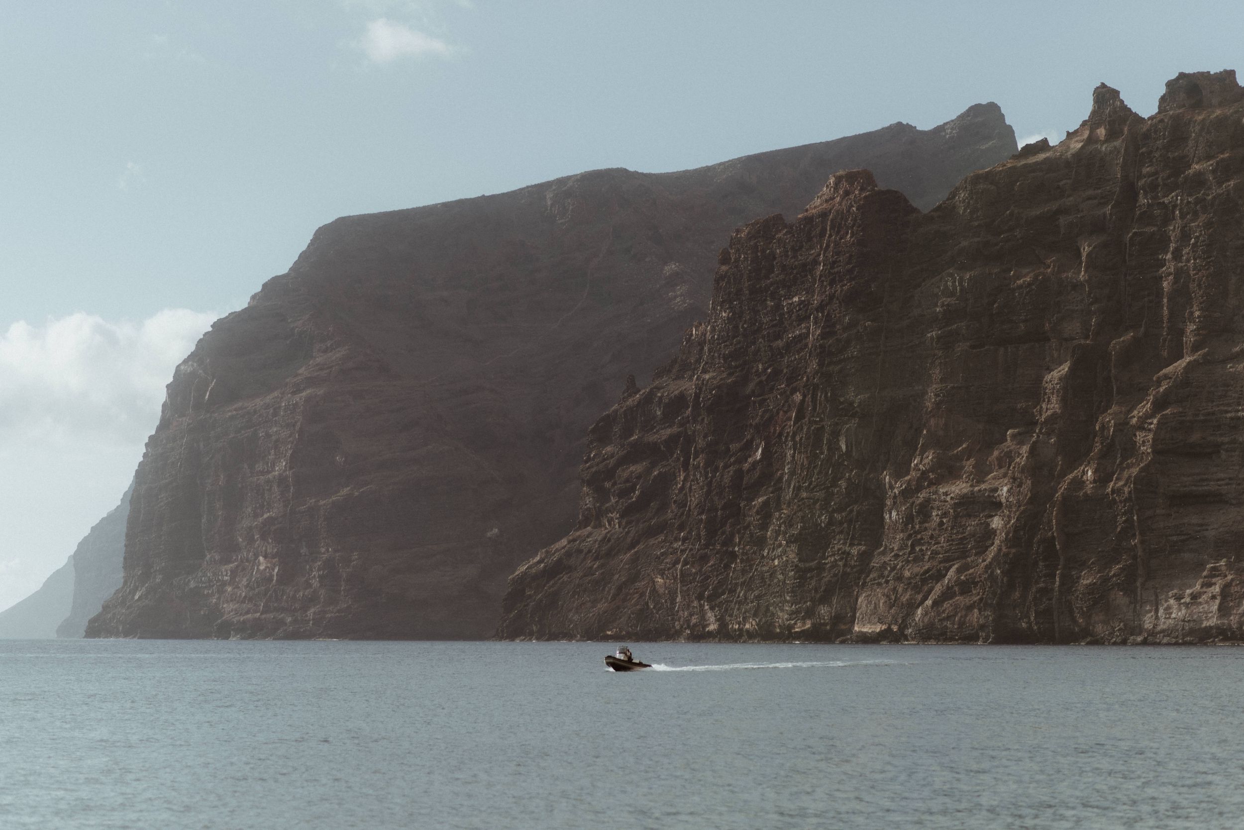 Panoramic view of steep coastal cliffs and rugged ocean coastline beneath dramatic cloudy skies of Los Gigantes.